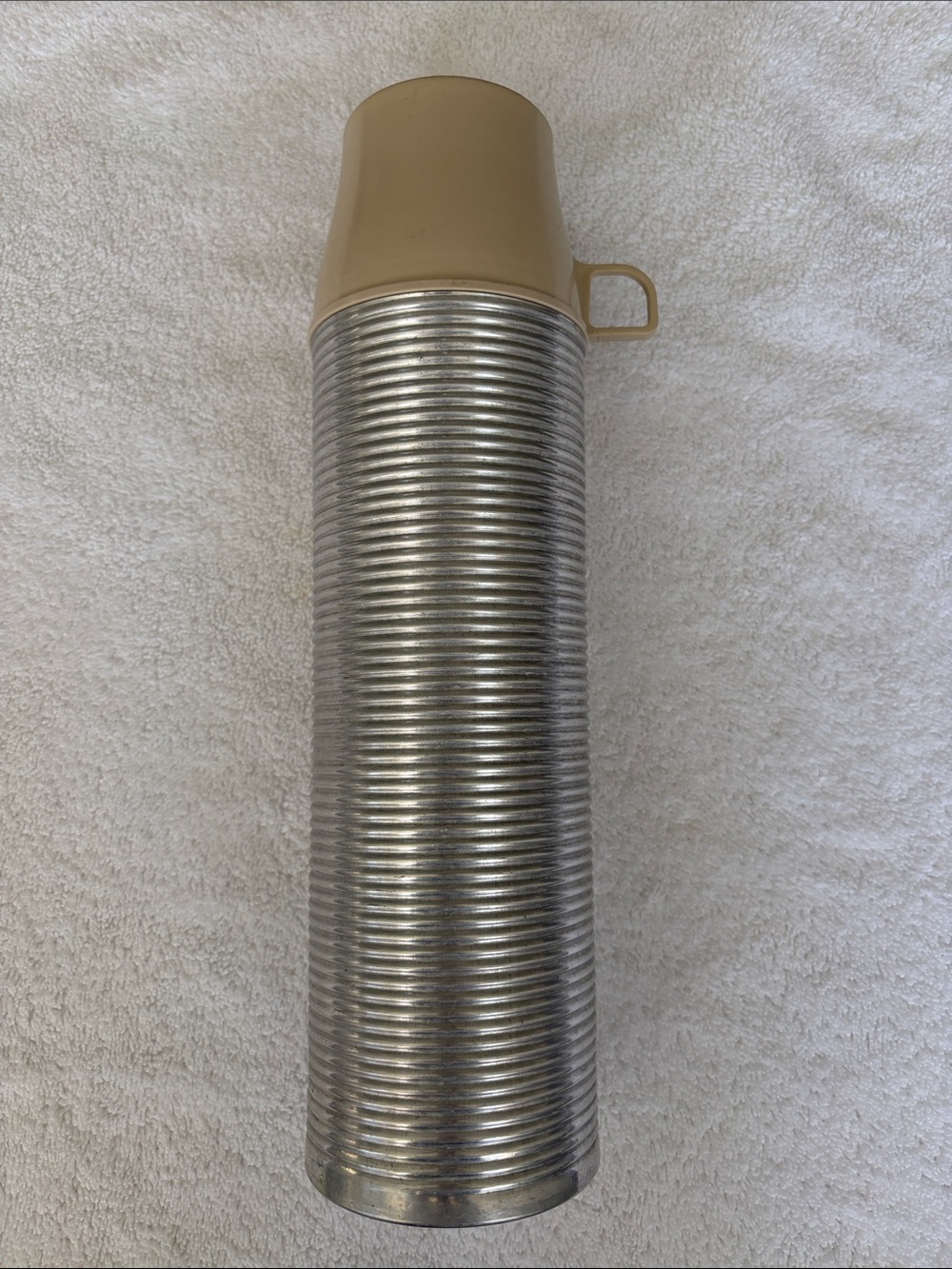 Vintage Thermos King Seeley ribbed aluminum thermos with tan plastic cup.